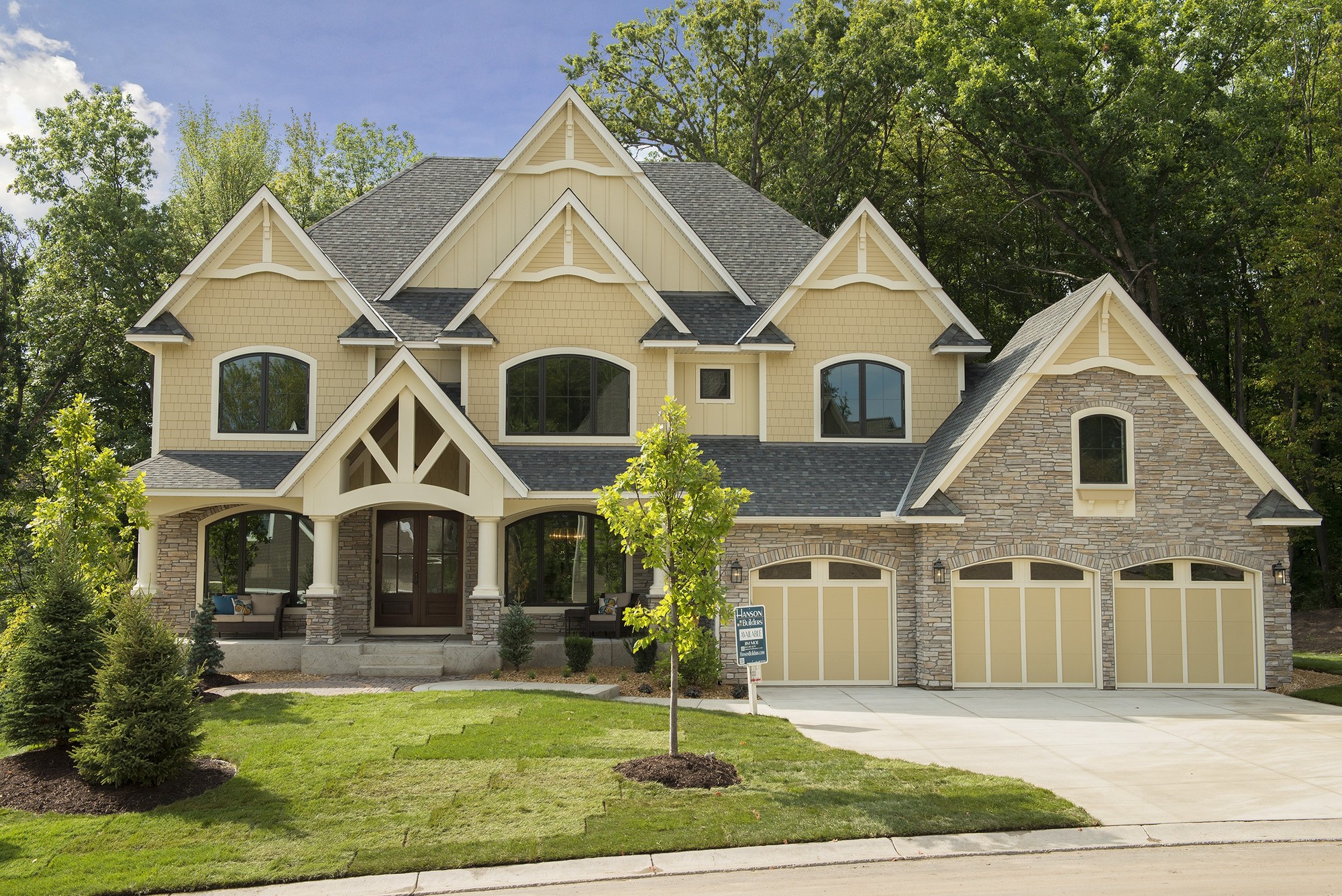 Modern interpretation of a Tudor home in Navajo Beige Hardie Panel with Stucco texture. 