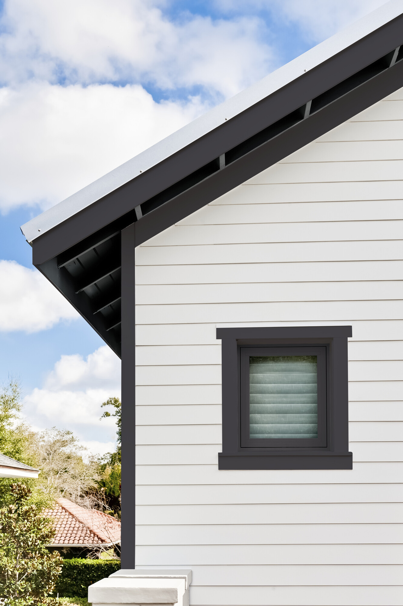 Detail of house clad in Evening Blue Hardie plank lap and Arctic White Hardie trim