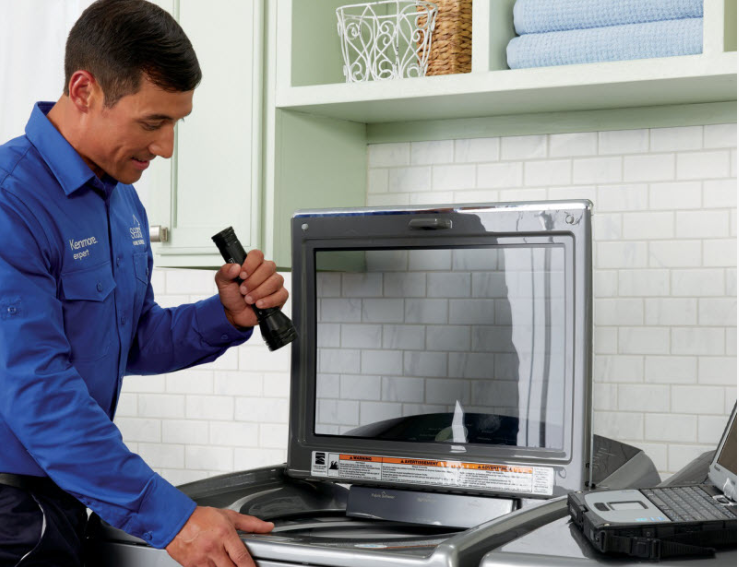 Sears Home Services Technician performing washer maintenance