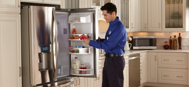 Image of tech repairing a fridge