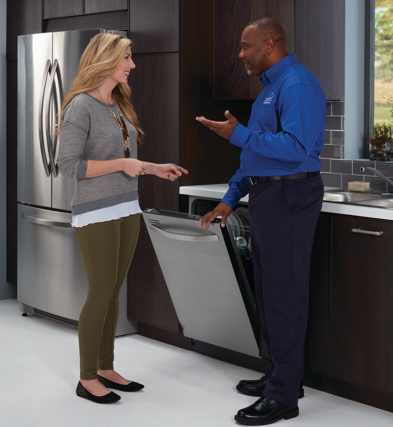 Sears Home Services Technician performing dishwasher cleaning and maintenance