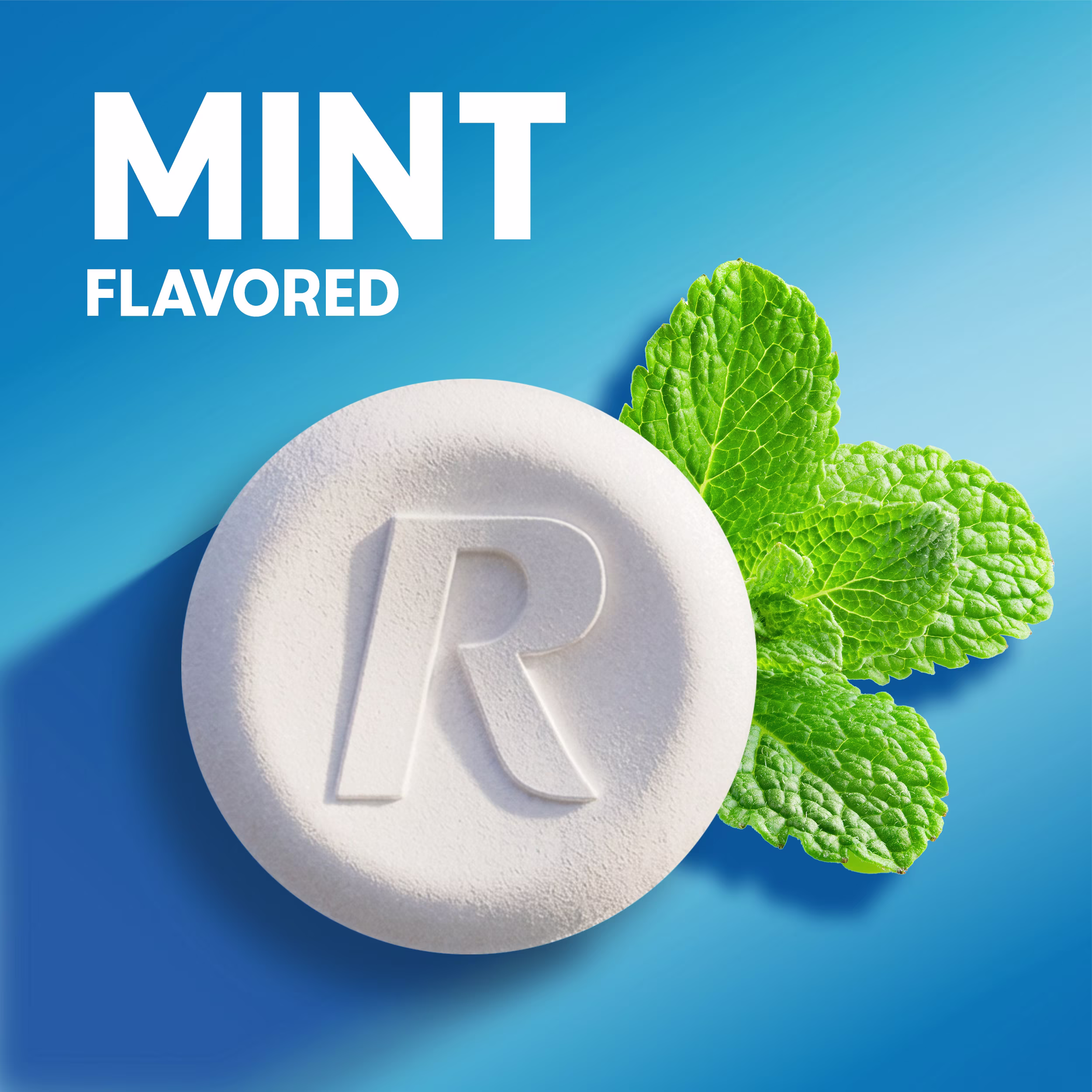 Close-up of a white chewable tablet stamped with an "R" next to fresh mint leaves with "Mint Flavored" text.