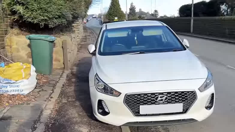 A white car parked on a footpath
