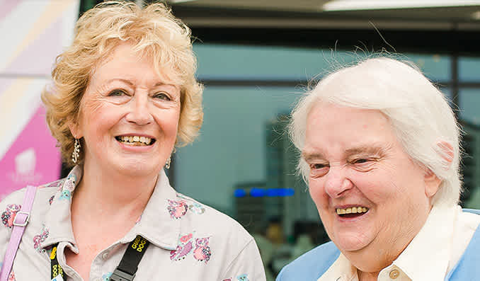 Two ladies talking and smiling. 