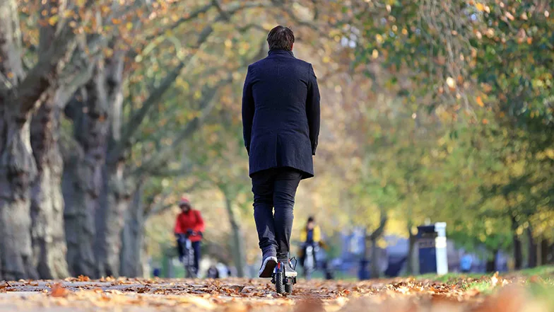 A man on an e-scooter in a park