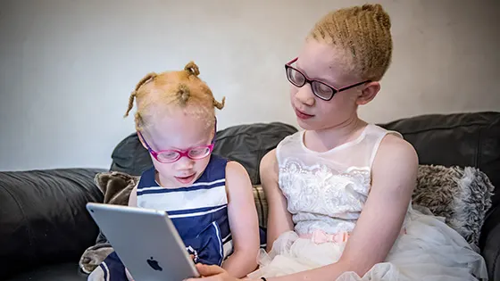 Kamsi and her sister, Nnenna, playing on their iPad