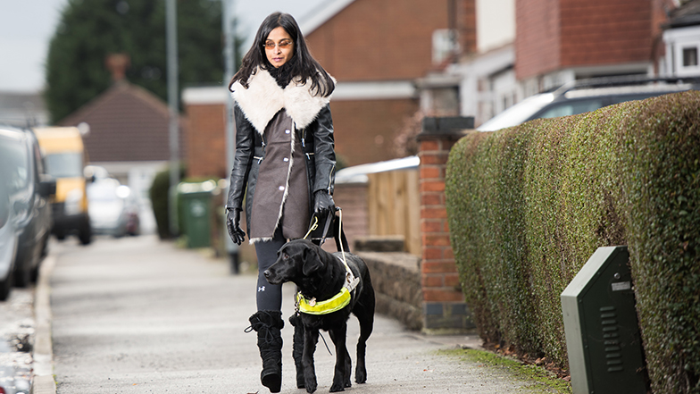 Guide dog owner Jaina walking with guide dog down a residential street