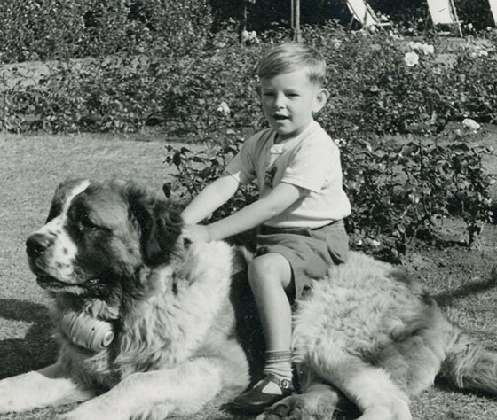 Rt Hon Lord Blunkett as a child sitting on top of a St. Bernard dog