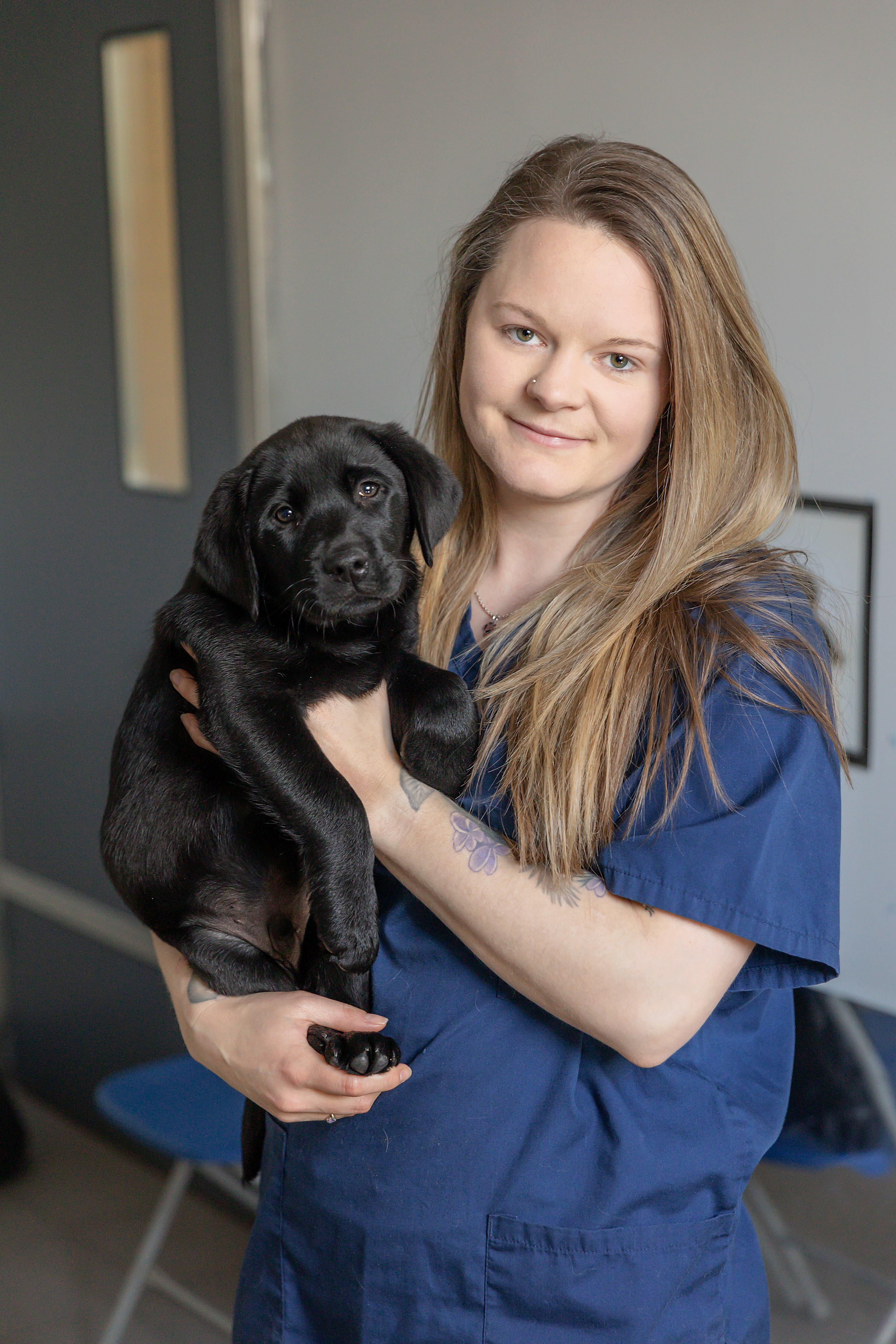 Becky Hunt holds a black labrador puppy in her arms.
