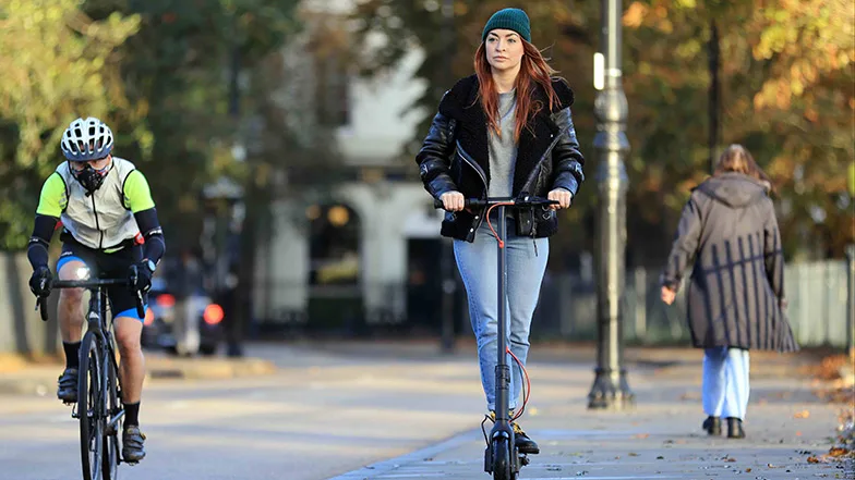 A woman on an e-scooter in a park