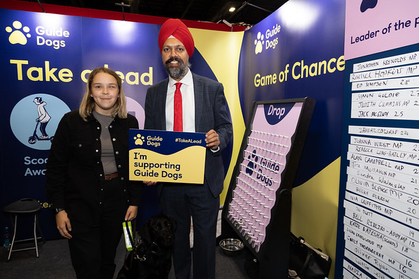 Labour MP Tan Dhesi  photographed with young service user Caitlin and her guide dog, Honey, at the Guide Dogs stand at the Labour Party Conference. 