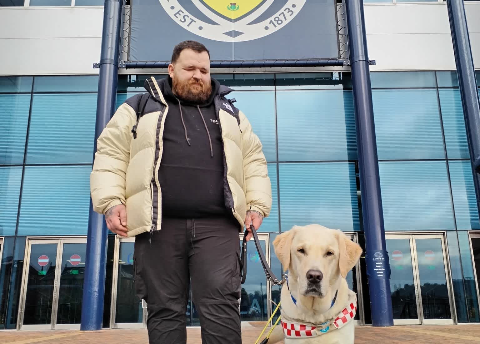 Jon and guide dog Sam outside Hampden Park Stadium in Glasgow