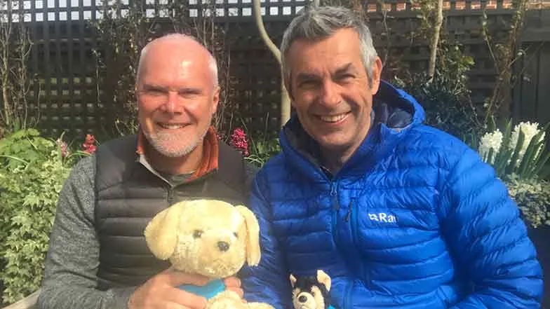 Designers Jonathan Smith and Adam Woolcott sitting in the award-winning Guide Dogs 90th Anniversary Artisan Garden at the RHS Chelsea Flower Show 2021