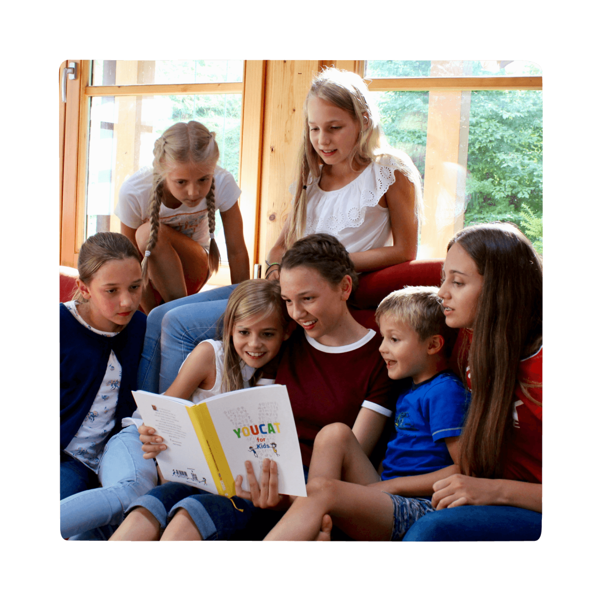 group of children reading youcat for kids book together