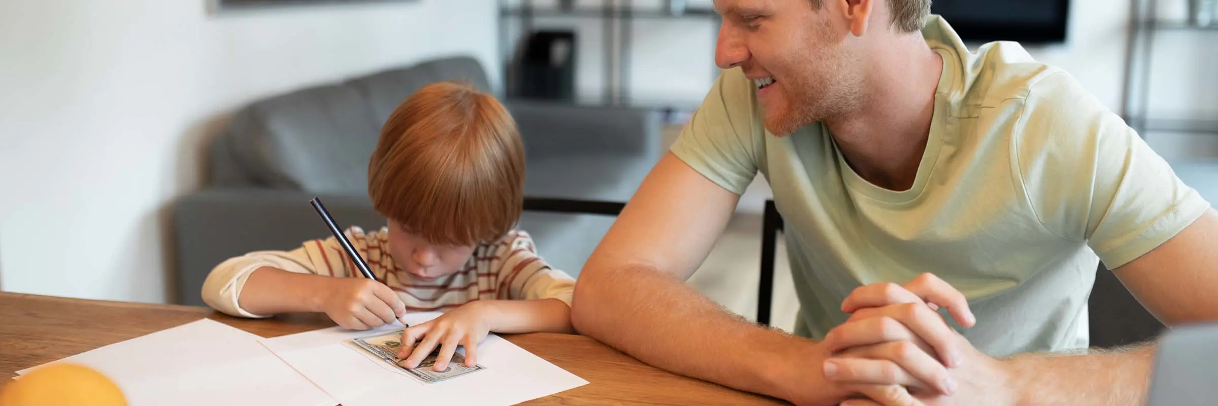 Father teaching his son about money at kitchen table. 