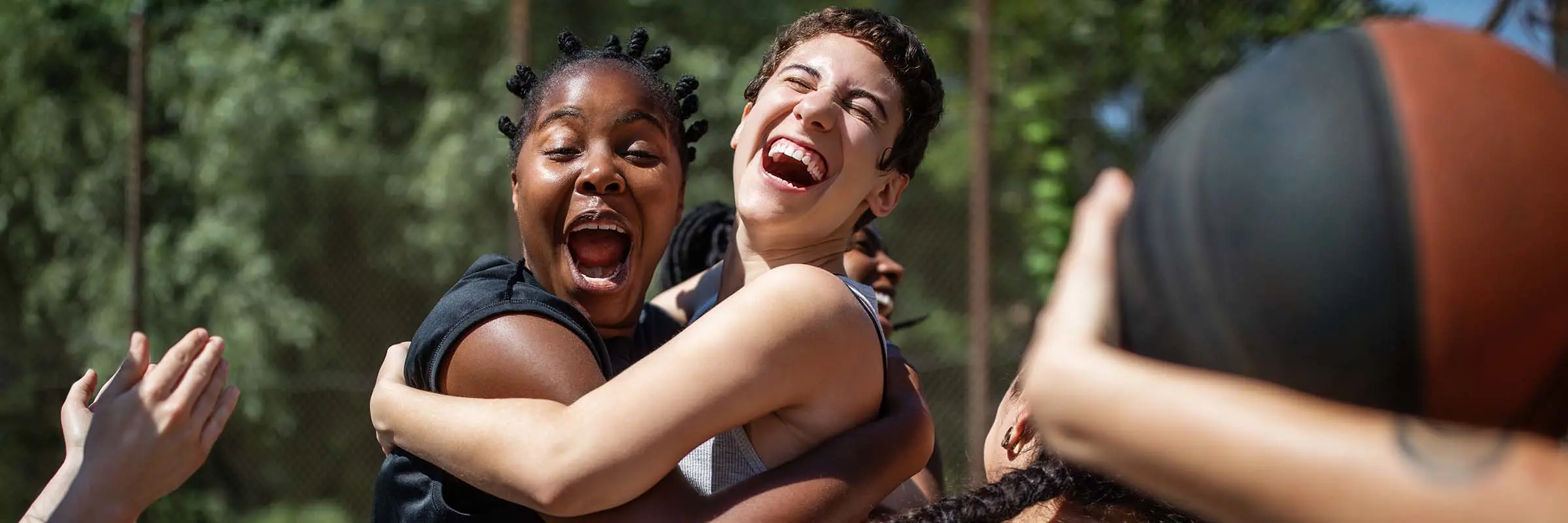 Teammates celebrate a victory on an outdoor basketball court