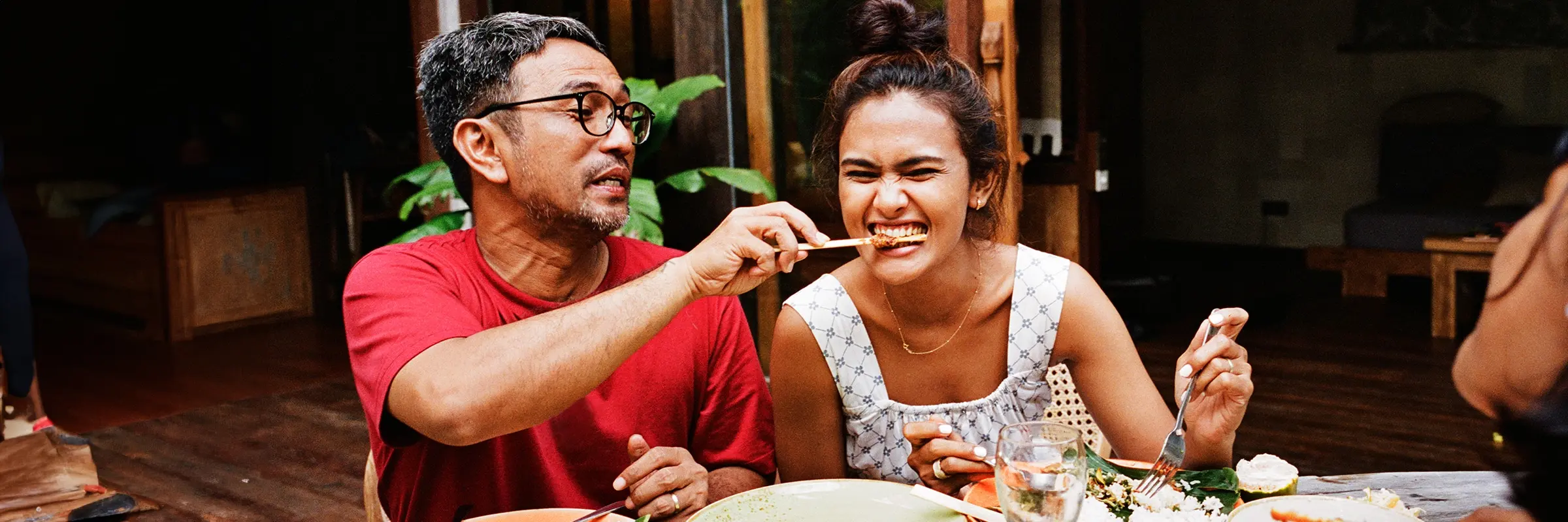 Man feeds woman a kebab at dinner with friends