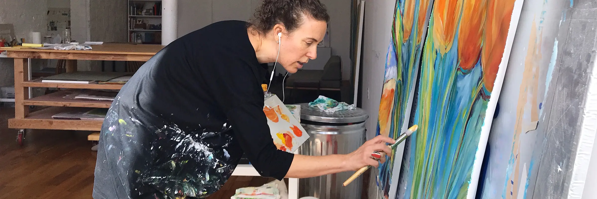 An artist paints in her studio while listening to music