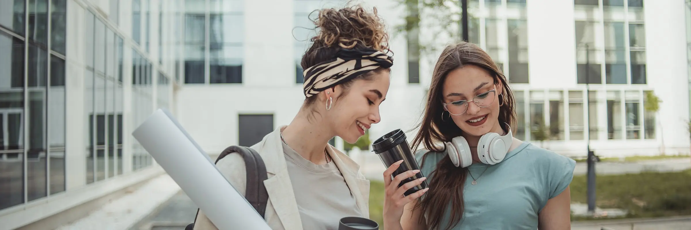 Two women going over papers while walking outside