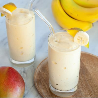 dreamsicle smoothie in a glass cup with banana and mango