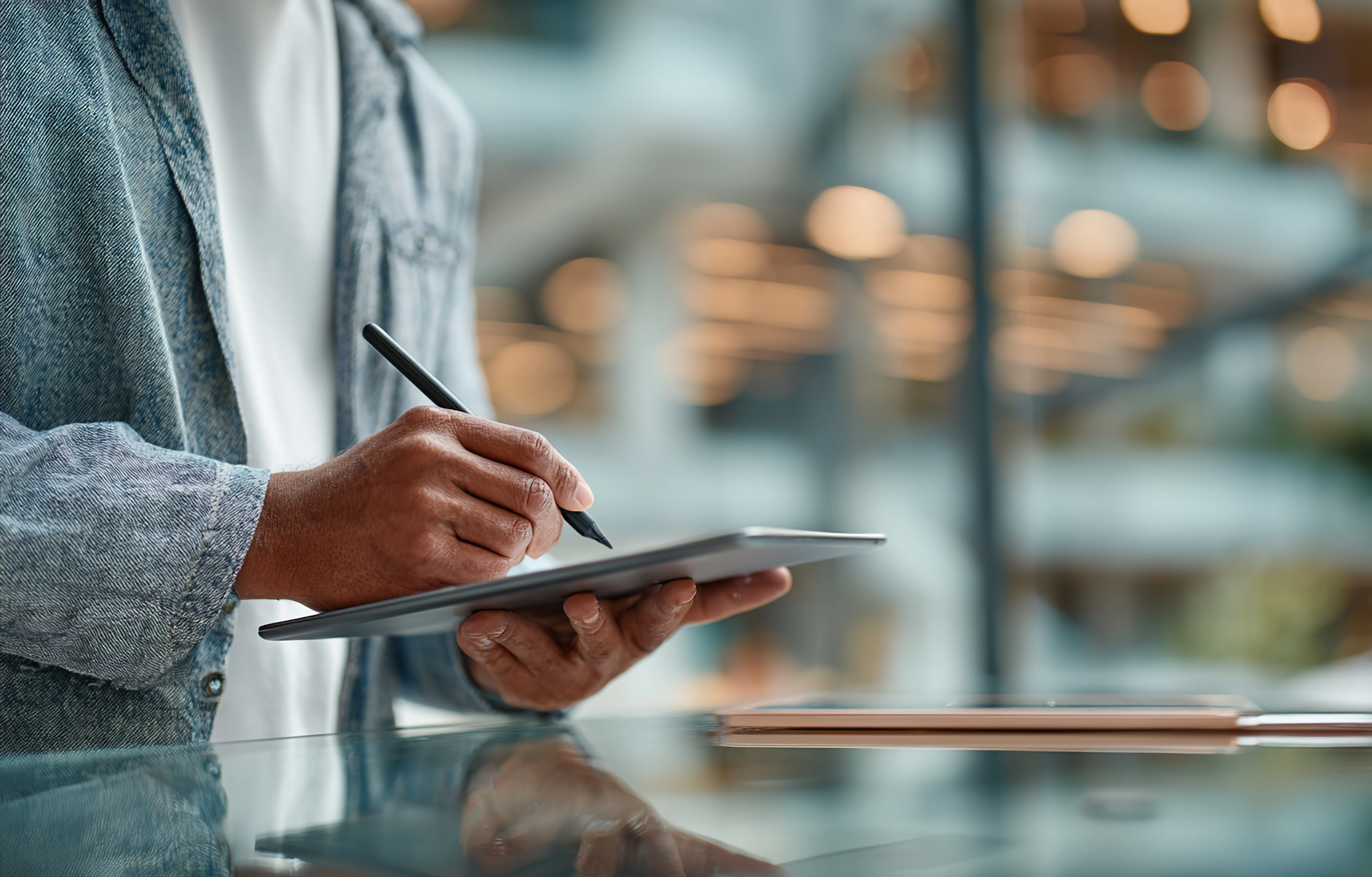 person holding a tablet with a stylus pen