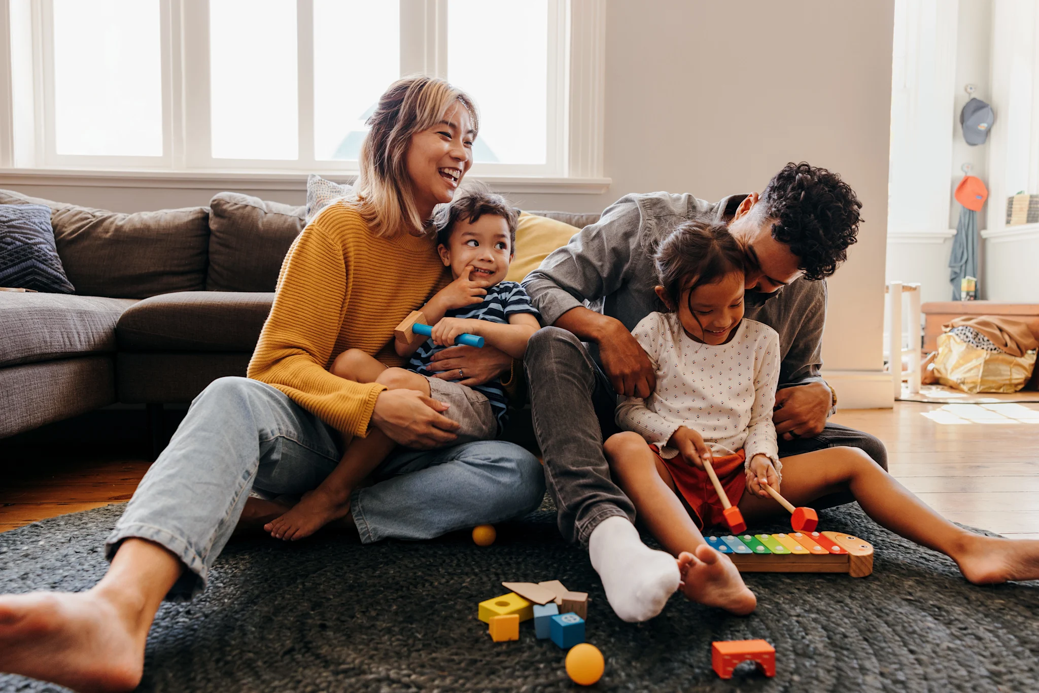 family of 4 smiling and having fun in living room