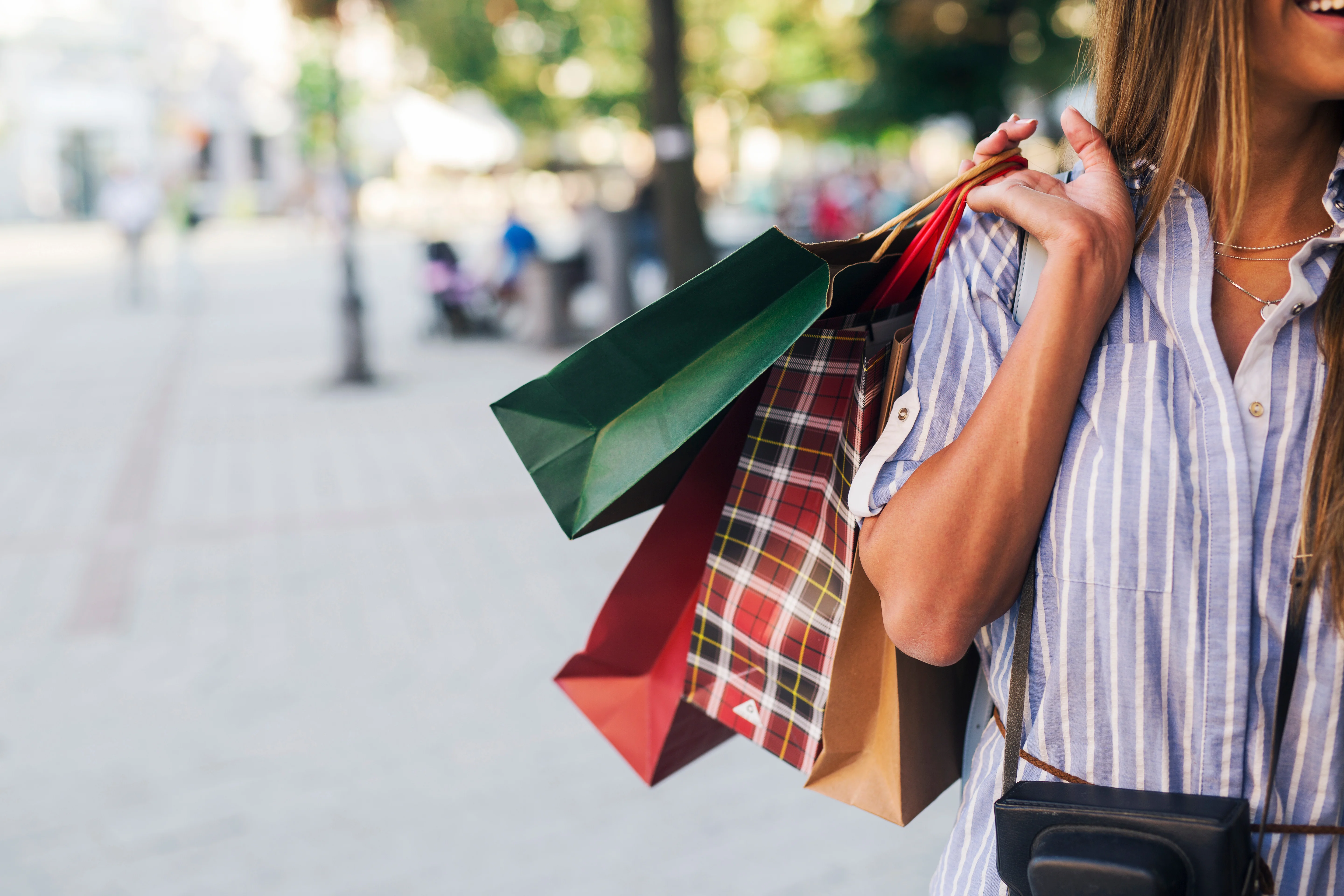 woman with long hair holding numerous shopping bags