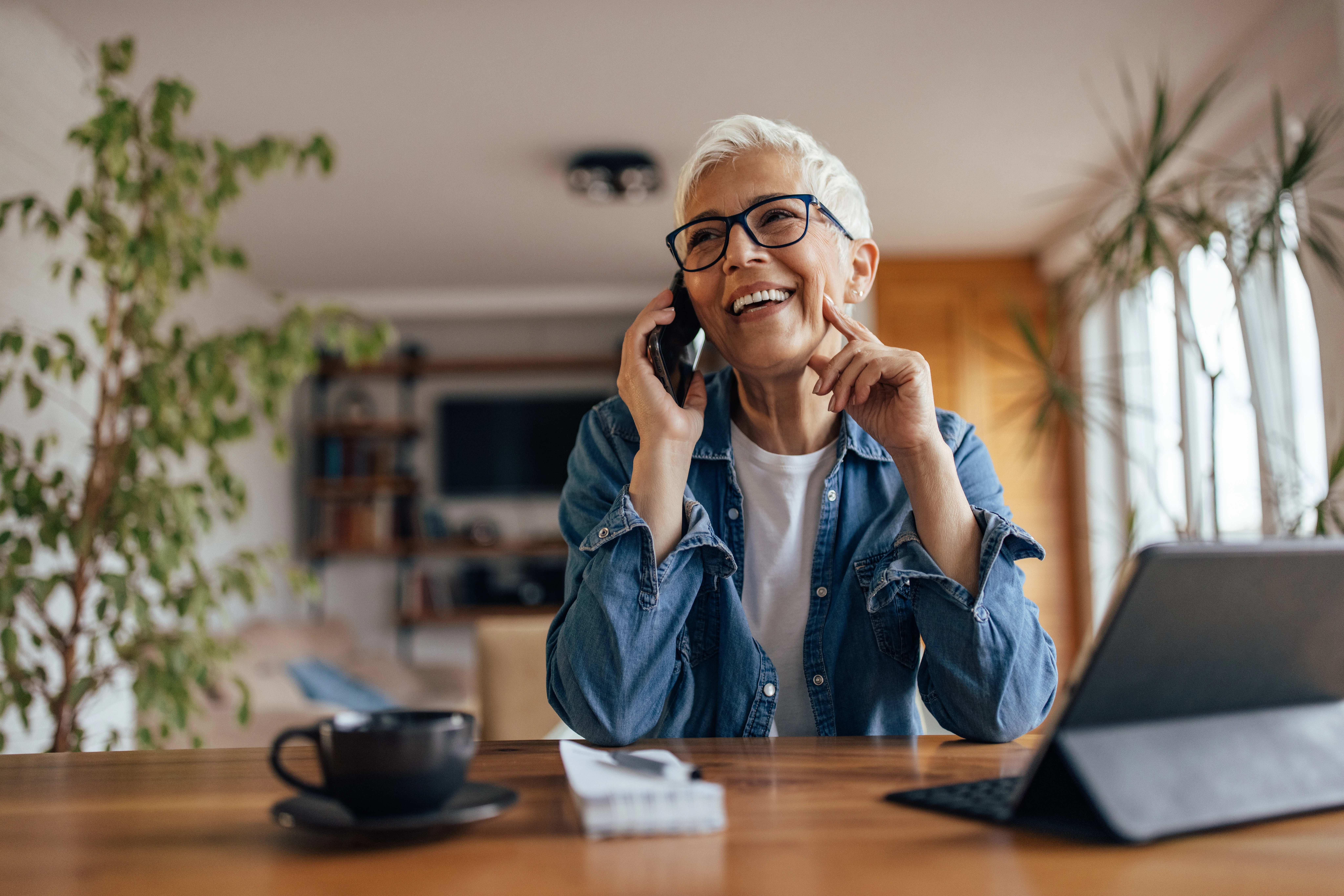 woman speaking on the phone at kitchen table 
