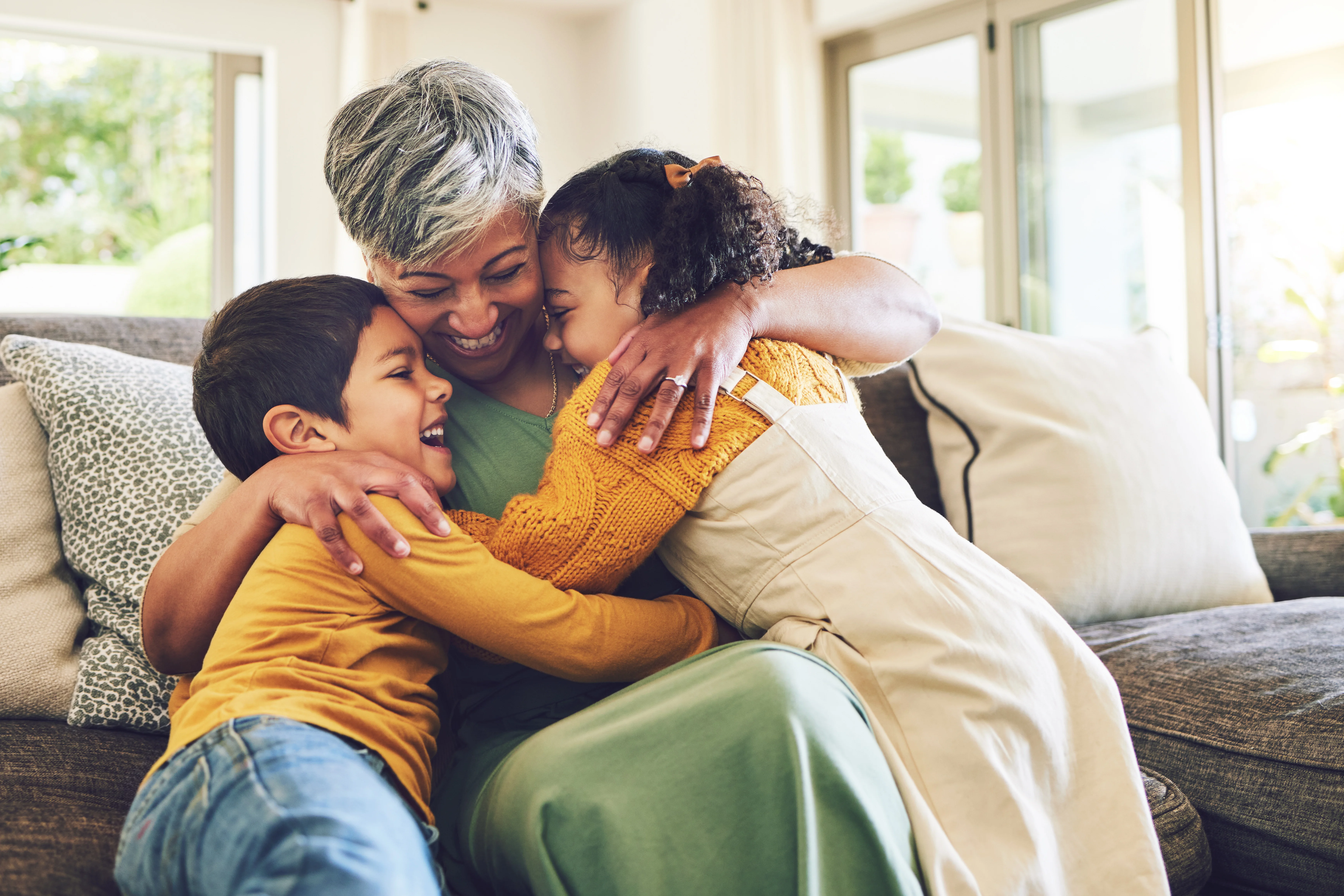 a grandmother hugging her two grandchildren 