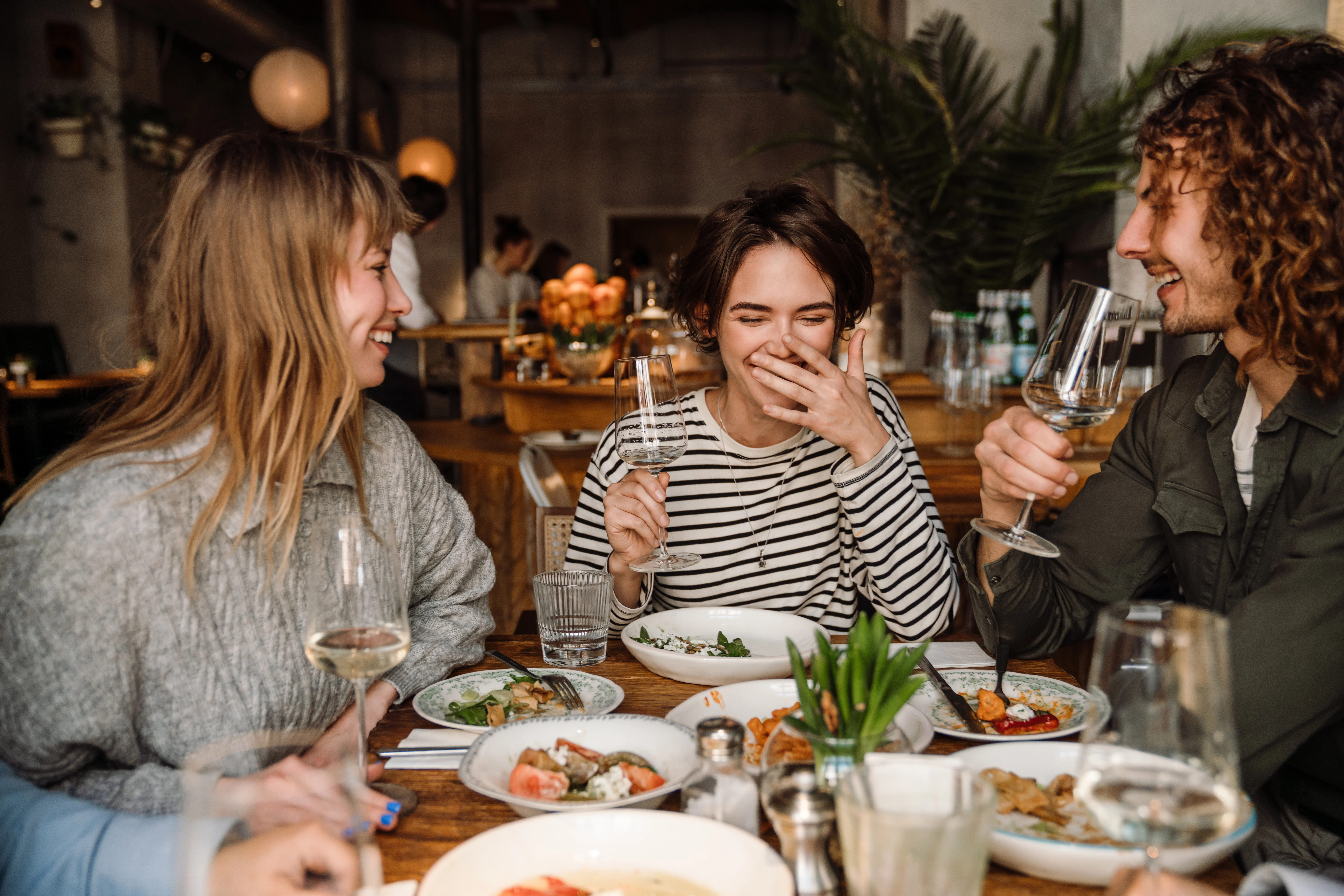 group of friends sitting at table dining out