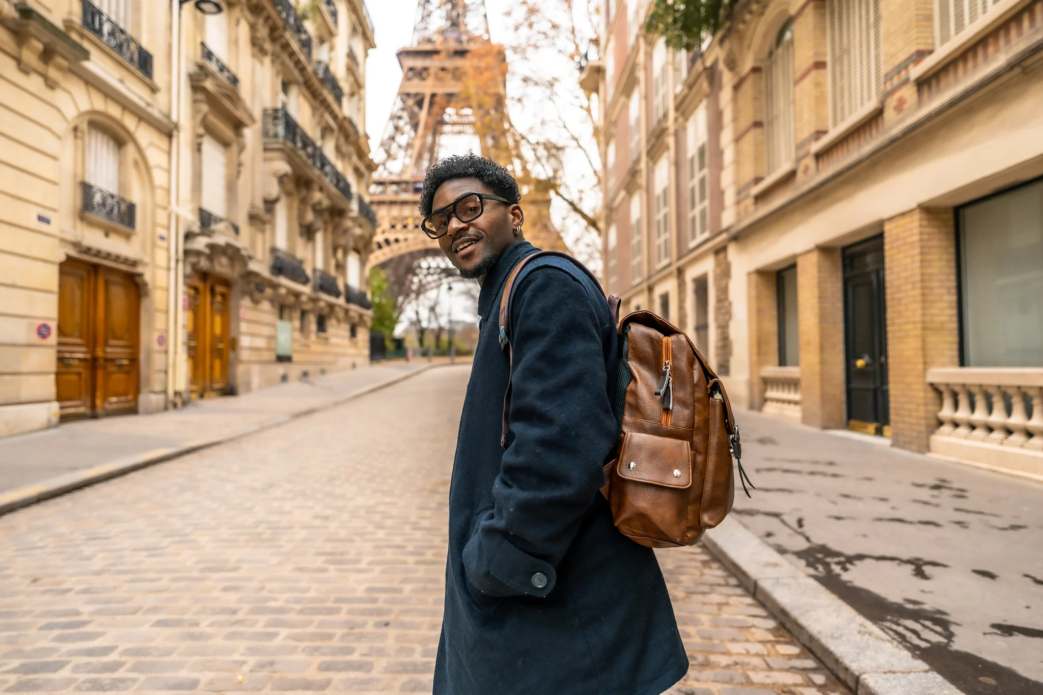 man with backpack in front of Eiffel Tower
