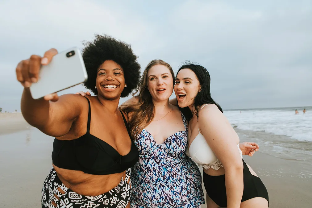 Drei Mädchen machen ein Selfie am Strand