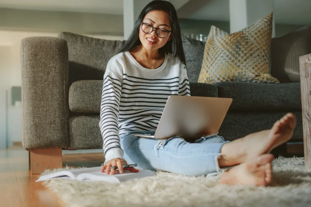Mädchen mit Laptop macht sich Notizen