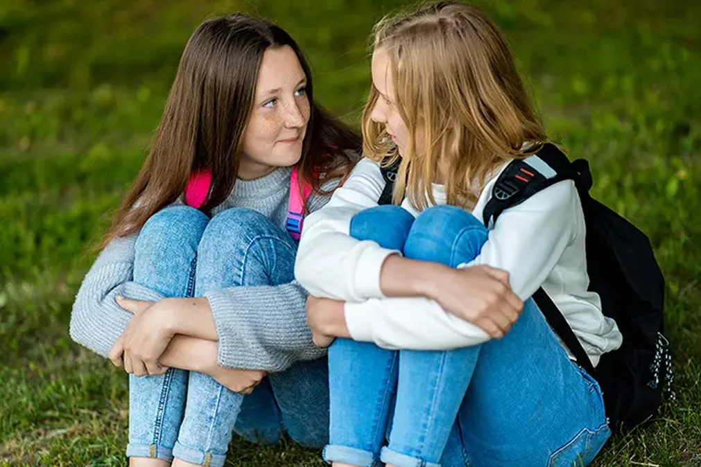 Zwei Mädchen sitzen auf dem Rasen