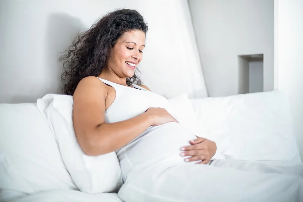 Schwangere Frau hält ihren Bauch