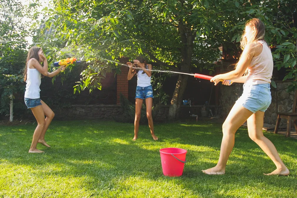 Drei Mädchen mit Wasserpistolen