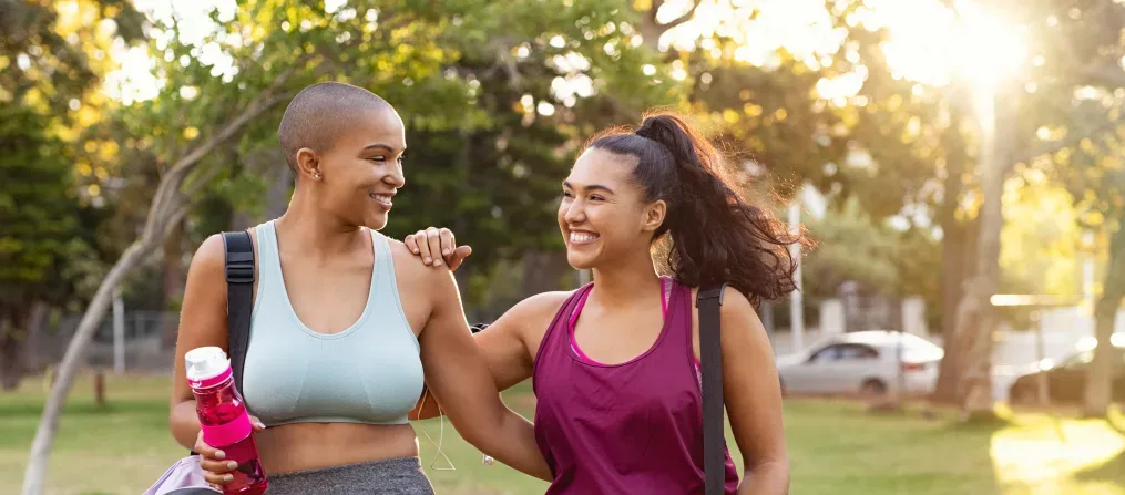 Zwei lächelnde Mädchen umarmen sich