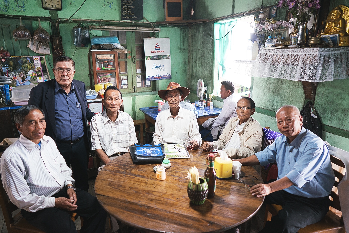 A group of older local men sitting around a table in Myanmar