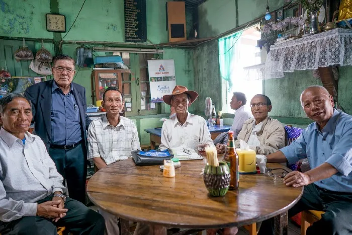 six men gathered around a table in a local restaurant