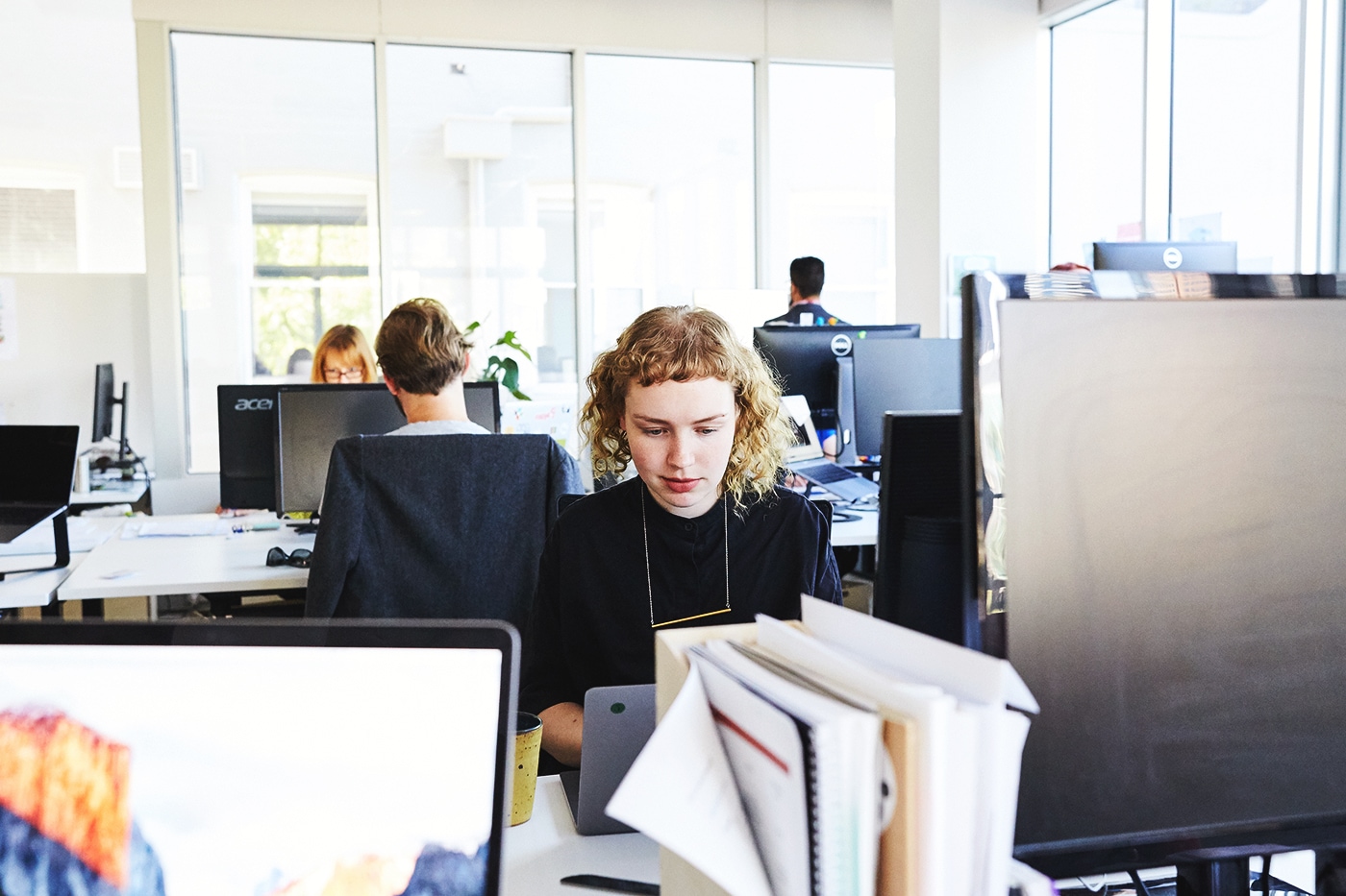 Designer working on their computer in the desk area of the Paper Giant office