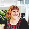 A photo of Rebecca LeSeouf in the Paper Giant Studio. It's a bright day and there's a plant and whiteboards in the background.