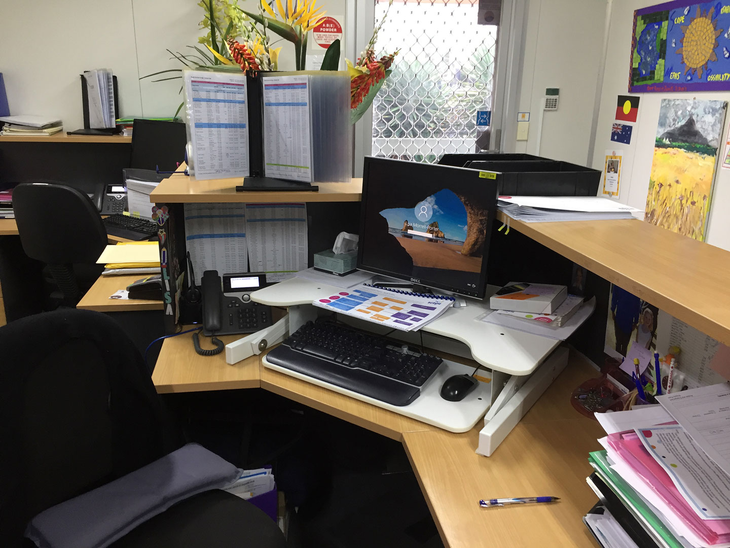 The desk of a Scope employee with a computer and paper tools that they use to onboard customers to the service.