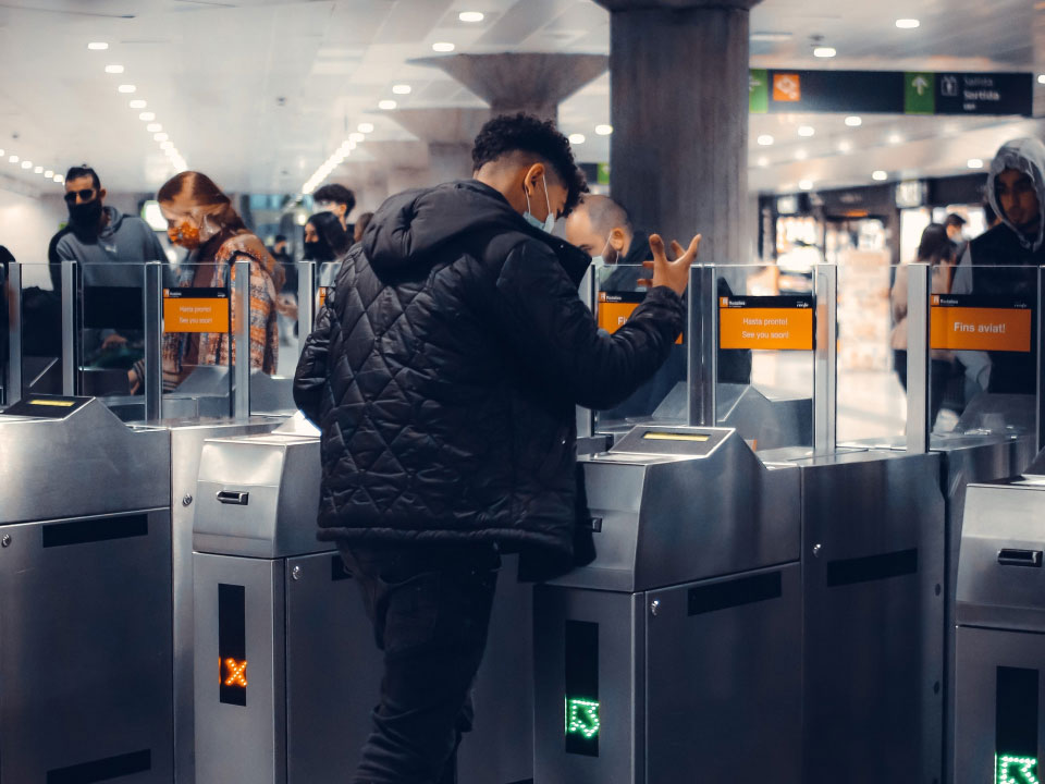 An image of a person accessing the subway network at a turnstile with facial recognition.