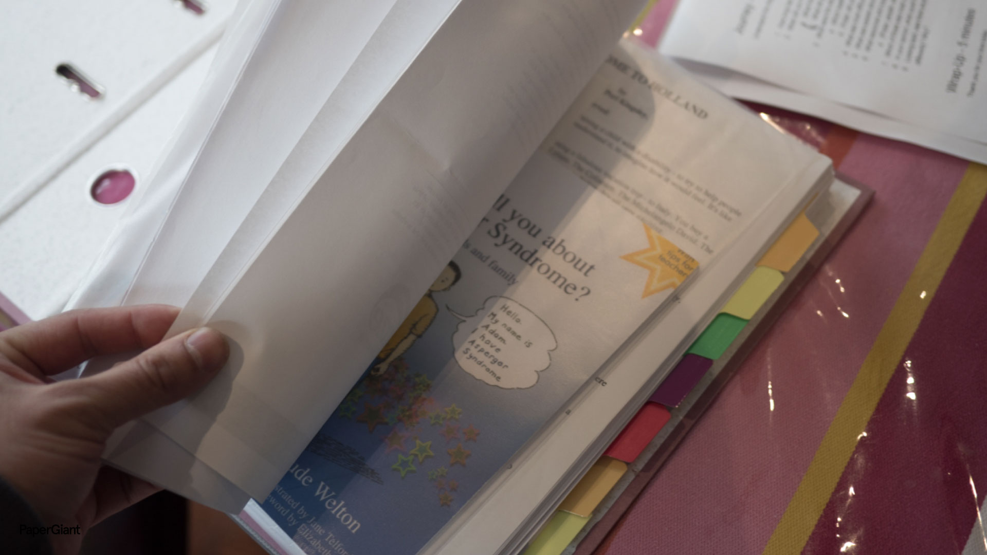 A close up of a folder with a hand turning the page