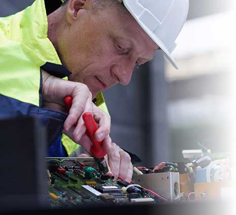 Worker in hardhat working on hard drive