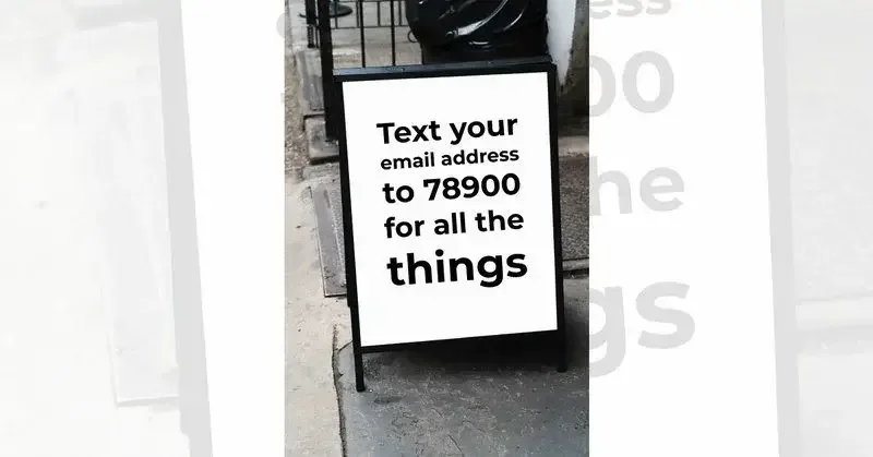 Outdoor sign with basic black on white message 'text your email address to 78900 for all the things