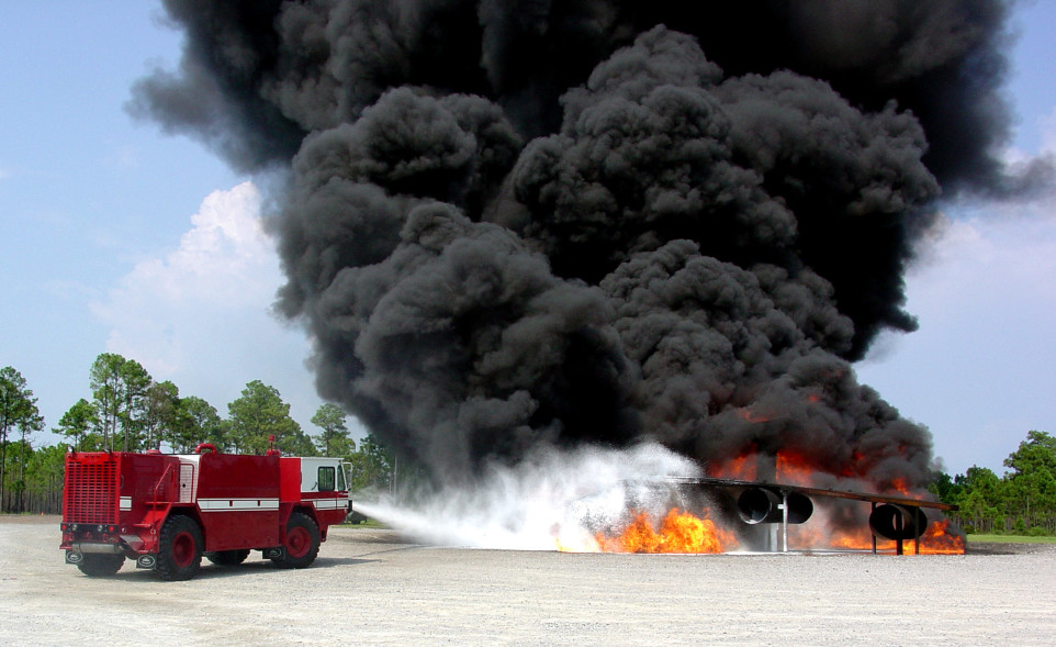 A fire truck uses its hose to extinguishes a fire.