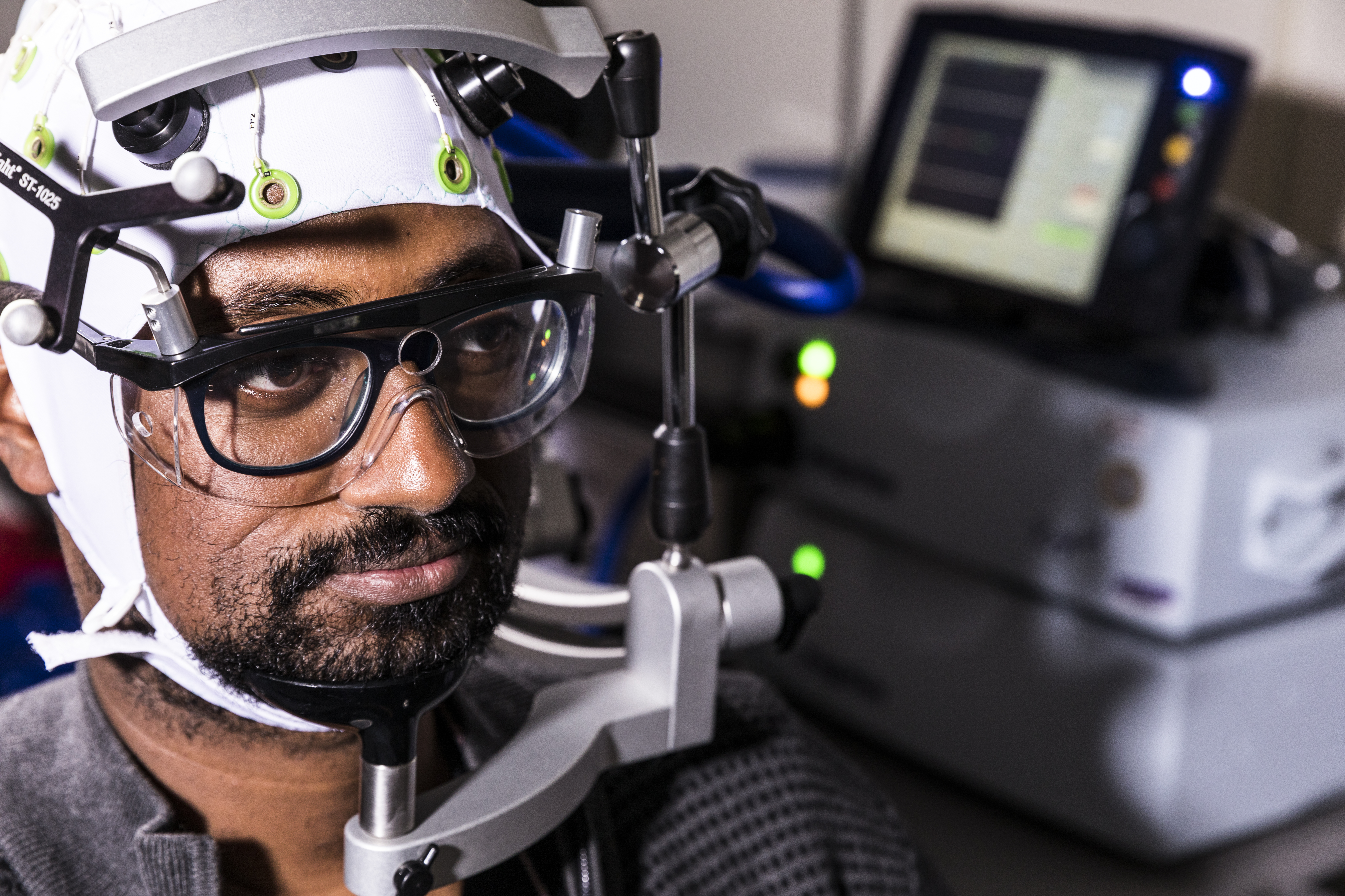 An example of a non-invasive BCI. Shown is a bidirectional device made of an EEG cap (for decoding) and magnetic stimulation coil (for transmitting information). Photo: Mark Stone / University of Washington.