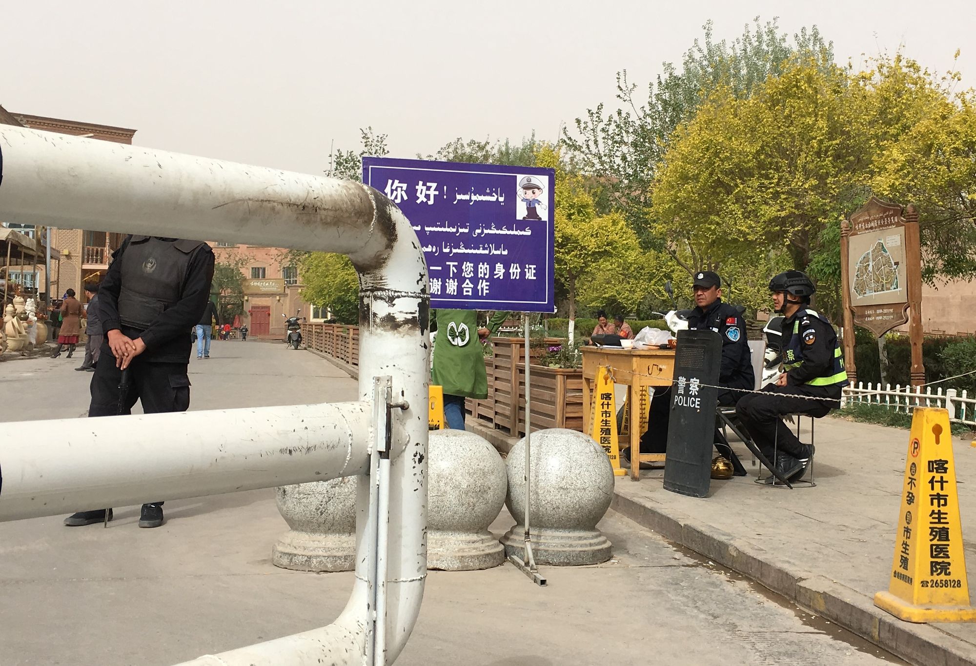 A sign with uniformed officers, behind a gate.