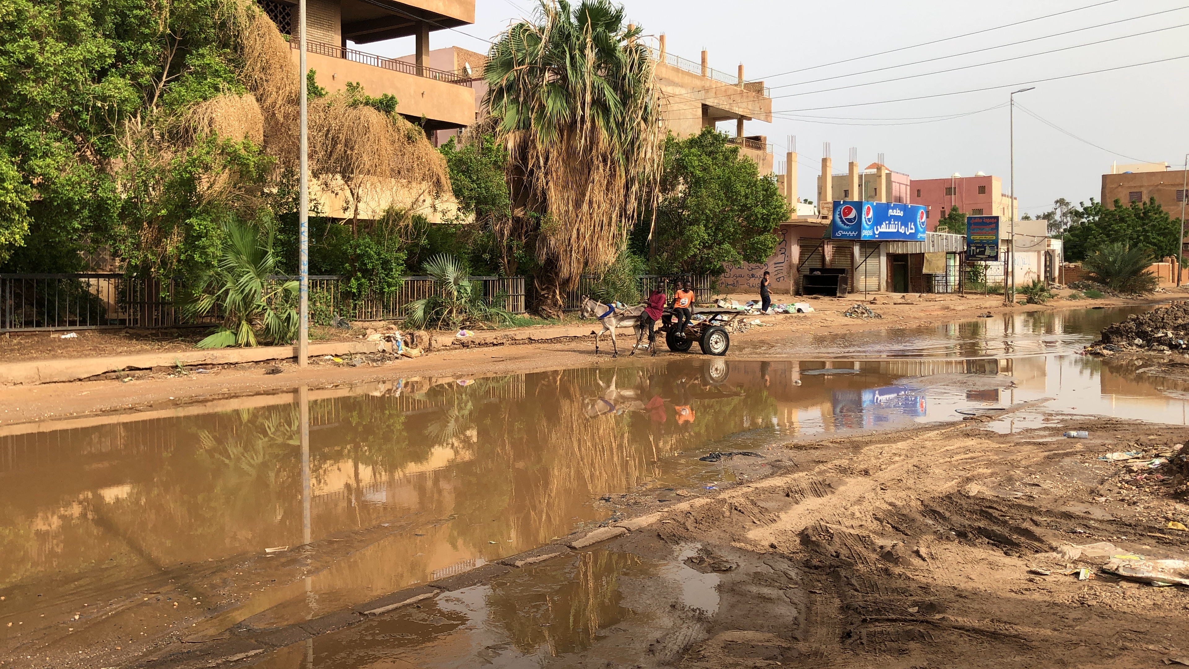 Children play on a donkey cart on a flooded street. Khartoum North, July 22, 2021. Photo courtesy of the author.